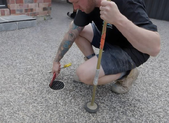 Plumber clearing an outdoor blocked drain